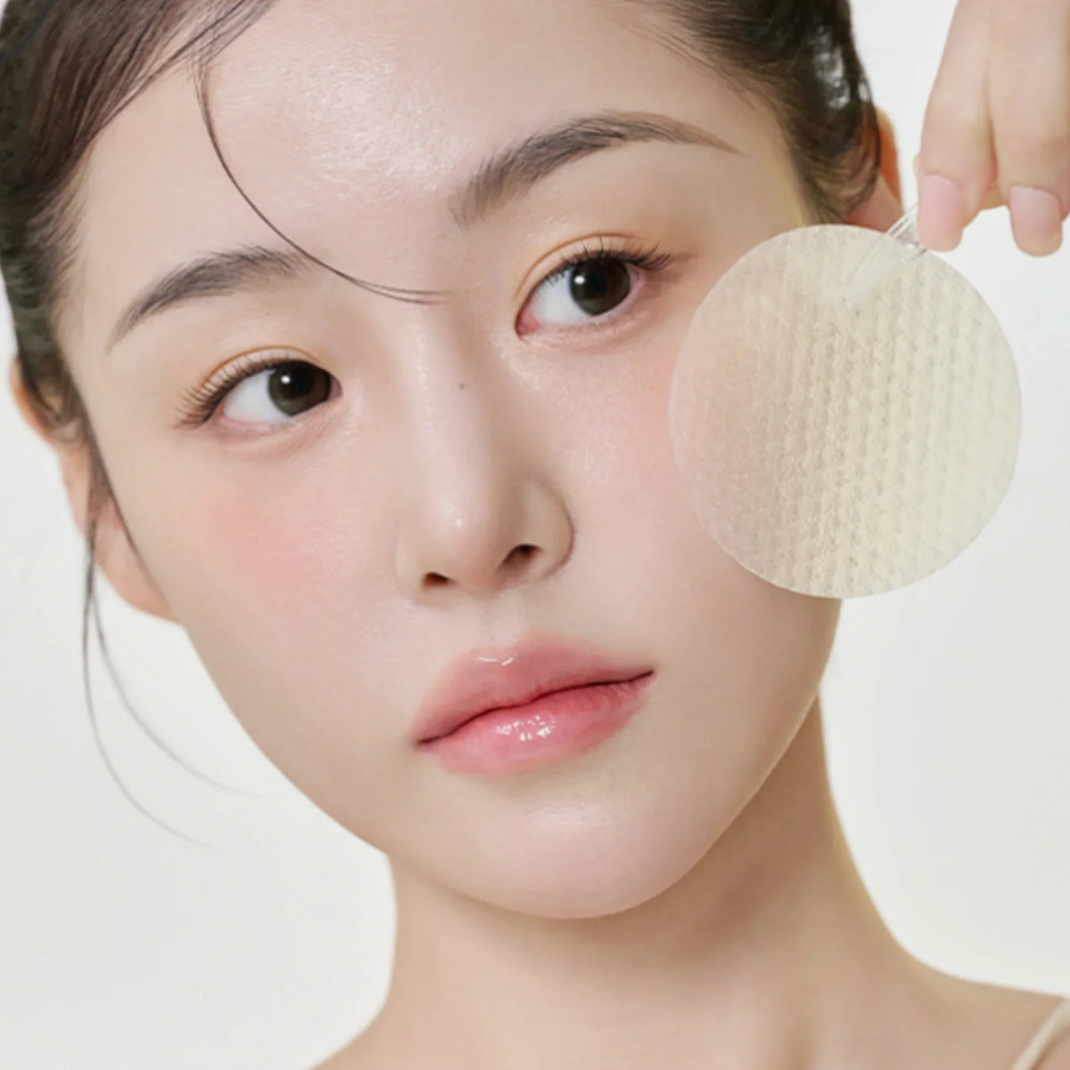 Woman using textured facial pad for skincare, clear glowing skin, Korean beauty routine